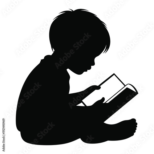 Silhouette of a young child absorbed in reading a book