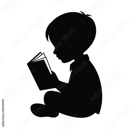 A silhouetted young boy engrossed in reading an open book