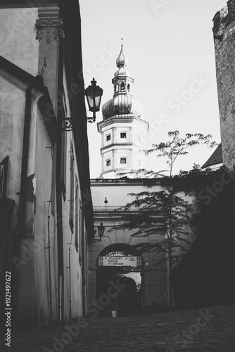 Black and White View of Mikulov Castle Tower Through Narrow Alley with Event Banner