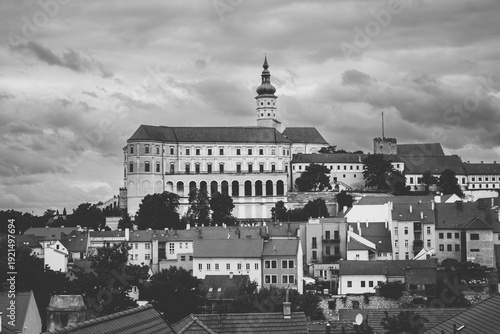 Artistic black and white monochrome photograph of the iconic Mikulov Castle overlooking the traditional rooftops of the old town in Czech Republic