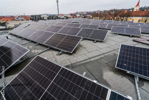 Rooftop solar panel installation on a flat roof with a city skyline in the background
