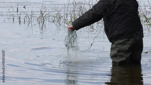 Close up Fisherman Hand Holding Fish Net. Male hands doing fishing with a rough old net.