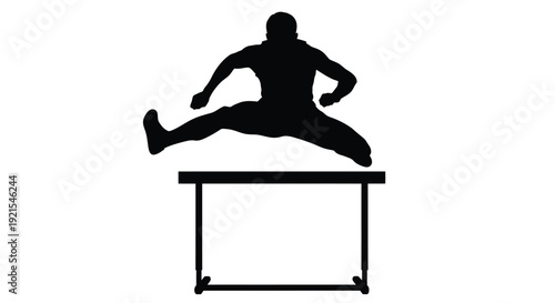 Silhouette of an athlete jumping over a hurdle in a track event