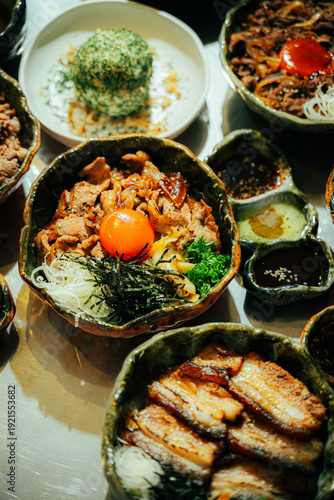 Close-up of a traditional Japanese beef rice bowl (donburi) topped with fresh raw egg yolk, shredded nori seaweed, green onions, and caramelized onions. Served in a rustic ceramic bowl with grilled po