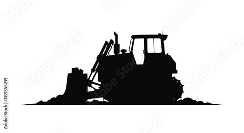 Black silhouette of a powerful bulldozer heavy construction machine pushing a pile of dirt with its front blade on a worksite.