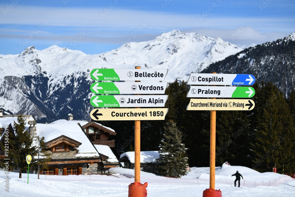 Fototapeta premium Direction signs on the slopes of Courchevel ski resort town at French alps by winter, showing Bellecote, Verdon, Jardin Alpin, Pralong and Courchevel 1850