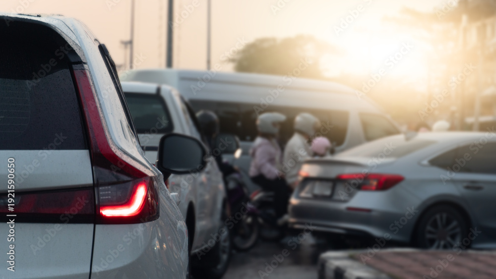 Obraz premium Abstract rear side view of white car open light brake. Front of car several cars prepare in a U-turn area. Traffic is congested during rush hour with both cars and motorcycles going to work or school.