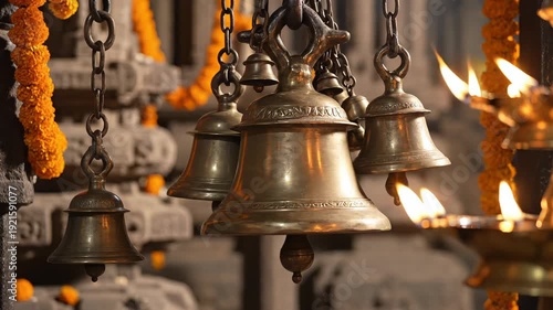 Close Up of Hanging Brass Temple Bells With Marigold Garlands and Oil Lamps