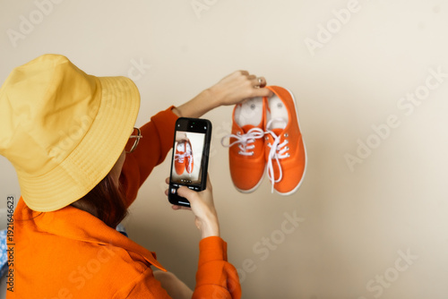 Quadro su tela Woman creating authentic user generated product photo of bright sneakers for onl
