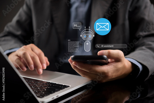 Photos Businessman using laptop and smartphone with virtual AI assistant and email hologram
