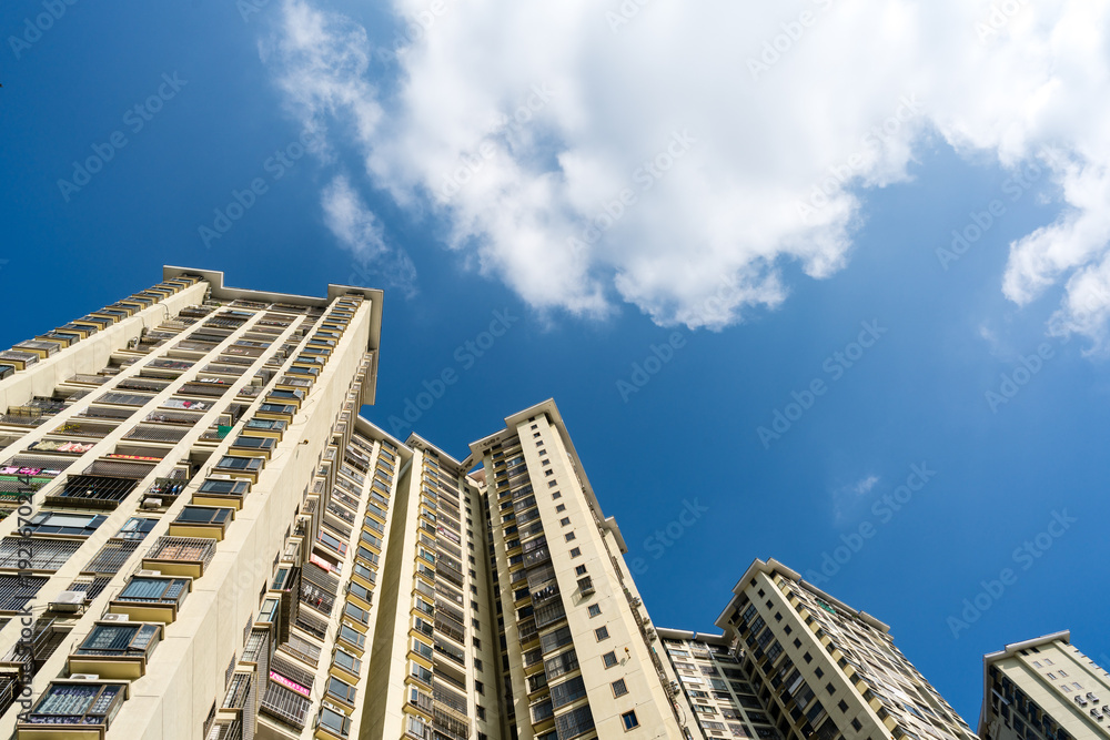 Fototapeta premium Modern Residential Apartment Buildings Elevation Shot Against Blue Sky