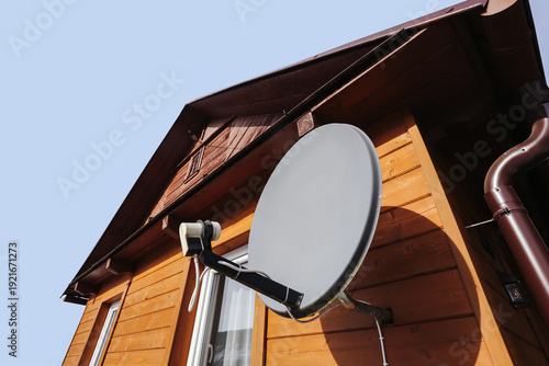 Konstfotografi Satellite dish mounted on wooden house facade
