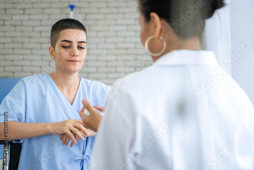 Female patient using inhaler under doctor supervision in hospital room
