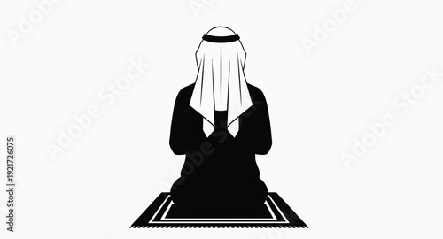 A kneeling man in traditional clothing facing mecca silhouette
