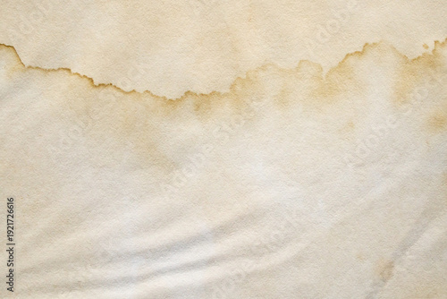 Old vintage paper texture background with aged stains and antique yellowed parchment effect
