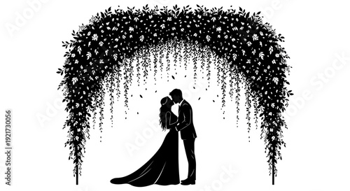 A silhouetted couple shares a tender kiss beneath a lush floral archway in black and white