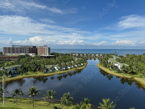 Foto Aerial view of a luxury tropical resort with white villas, winding lagoon, palm