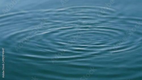 Sunlit Ripples Overhead shot of small, perfectly formed concentric ripples on clear water, shimmering with natural sunlight reflections.