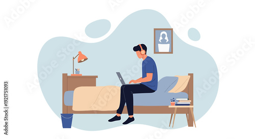 Young man working on laptop computer sitting on bed.