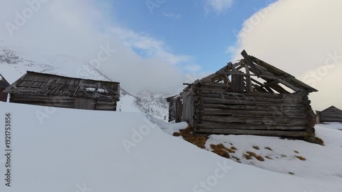 Rustic Abandoned Cabins in Snowy Mountain Landscape