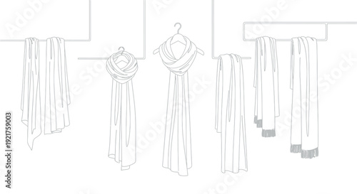 Various stylish scarf accessories displayed neatly on hanging racks and hangers demonstrating different folding techniques for retail presentation or fashion catalog imagery
