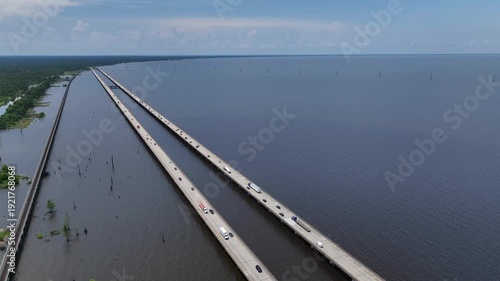 Cars Traveling on raised highway over Louisiana Lake Ponchartrain beside natural wetland bayou at Good Hope, LA