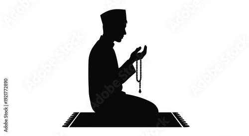 A muslim man kneeling in prayer holding beads a striking silhouette