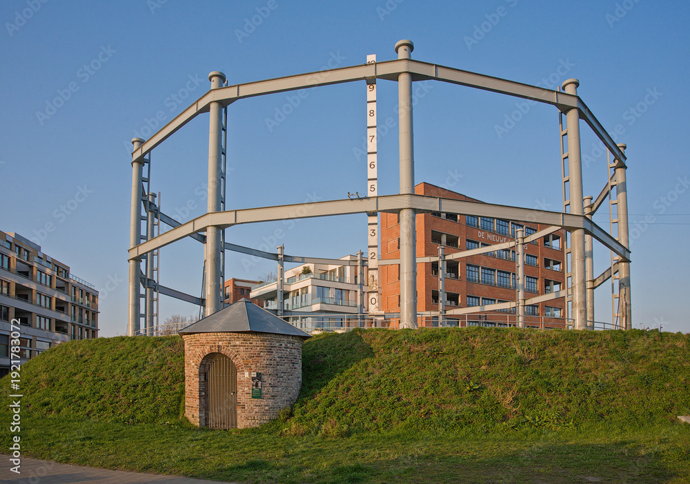 Fototapeta premium Restored old gas storage tank in a newly made park with modern apartment buildings on the Tondelier site in the city of Ghent, Belgium 