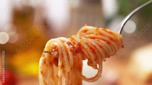 Spaghetti Bolognese Winding Onto a Fork - from a View of the Entire Dish on the Plate to a Close-up of the Strands of Pasta on the Utensil