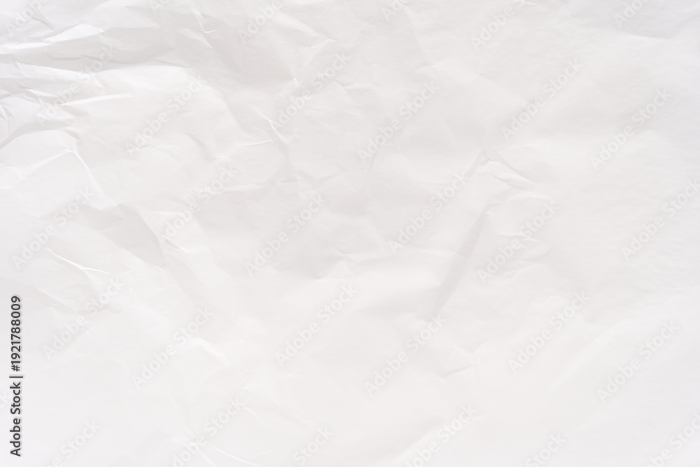 Naklejka premium Crumpled white paper texture with soft shadows for design and creative background projects.