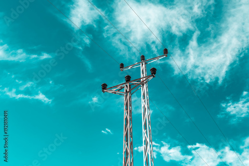 Electricity transmission line. High-voltage power line poles. Abstract blue sky background.