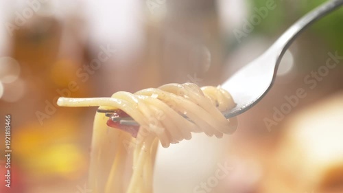 Spaghetti Carbonara Wrapping Around a Fork - from a View of the Dish on the Plate to a Close-Up of the Strands of Pasta on the Silver Utensil