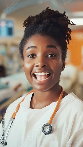 A female doctor, African American, looks at the camera and speaks, in a hospital