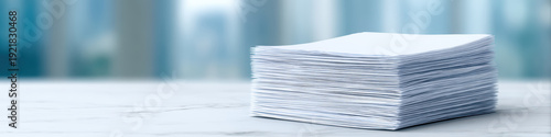 Stack of white documents is neatly arranged on marble surface, showcasing minimalistic style. blurred background adds professional touch, enhancing editorial feel of image