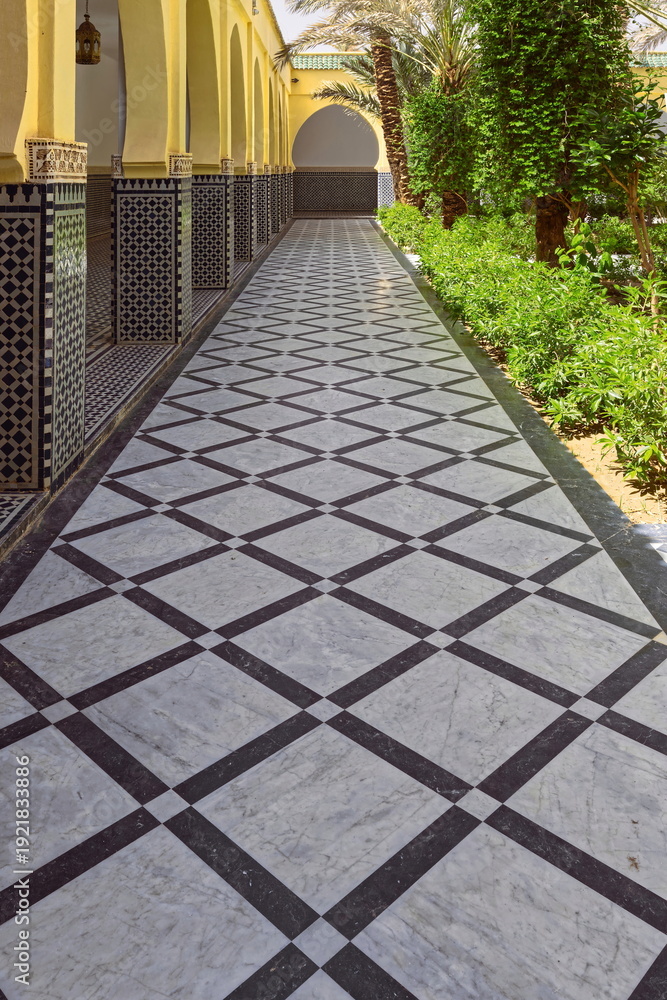 Naklejka premium Side passageway with black-white tiled floor between the south hallway and the central gardens of the Moulay Ali Cherif mausoleum. Rissani-Morocco-148