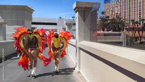Photography Two performers dressed in flamboyant feather showgirl costumes and heart wings w