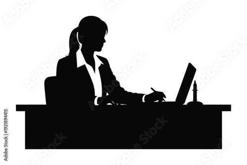 Silhouette of a businesswoman typing on a laptop at her desk writing notes