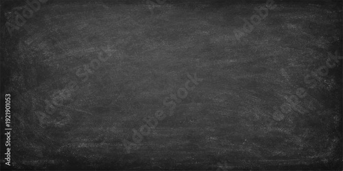 A dark and vintage grunge chalkboard texture features a blank, dirty black surface framed by a gray concrete wall backdrop for a weathered design