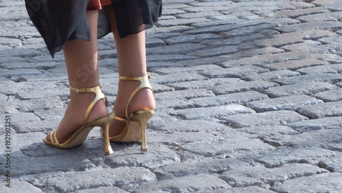 Women's feet in gold-plated heels.