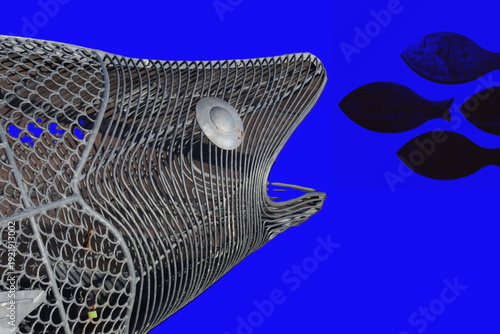 Metal robot skeleton fish chasing other metal fishes
