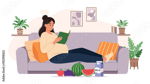 Pregnant woman sitting on sofa in living room reading book and eating healthy snacks, enjoying quiet time at home.