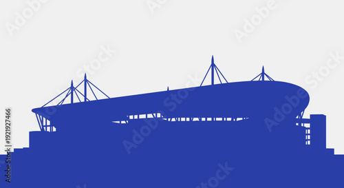 Silhouette of a ship passing under a large suspension bridge over calm water at sunset in a coastal city