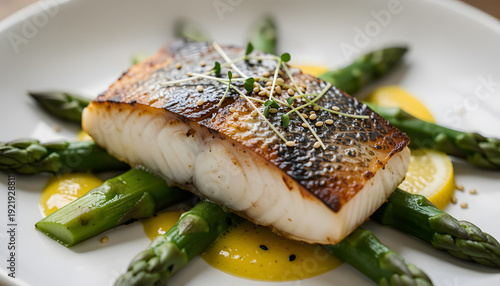 Elegant macro food photography of a delicate white fish fillet served on fresh green asparagus with classic French beurre blanc white wine sauce and lemon on a white plate. Refined gourmet restaurant 