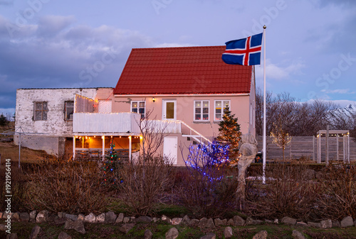 Foto The icelandic flag in front of a house on island of Hrisey in Iceland