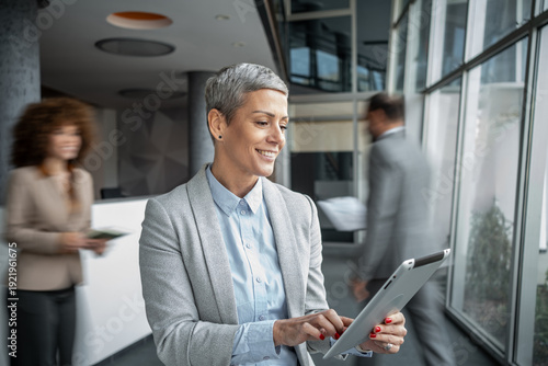 Foto Businesswoman using digital tablet smiling at modern office