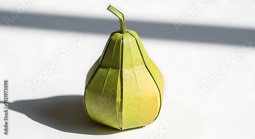 Paper origami green pear model on white surface