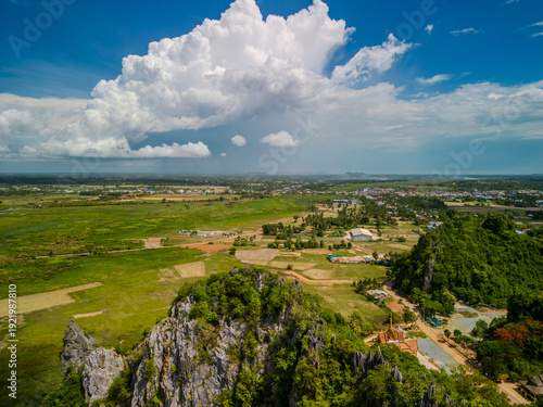 Obraz na plátně Limestone hills and rural farmland under dramatic clouds in Kampot Province
