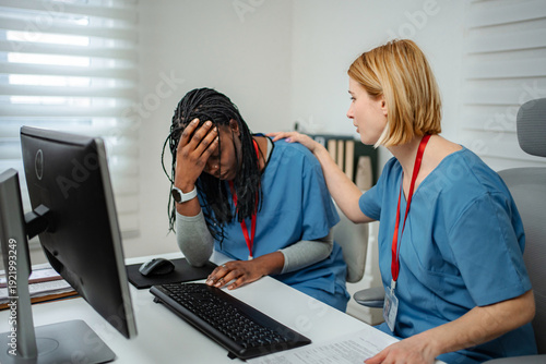 Photos Healthcare worker experiencing burnout with supportive colleague