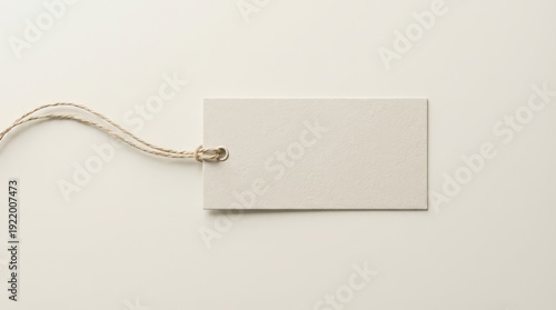 Blank white paper tag with twine on plain background