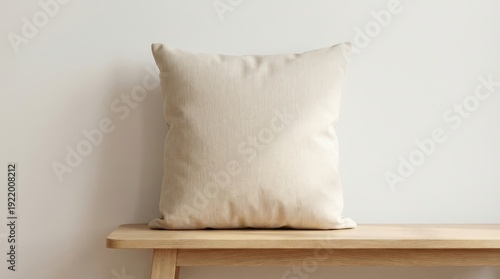 Square beige pillow resting on a wooden bench